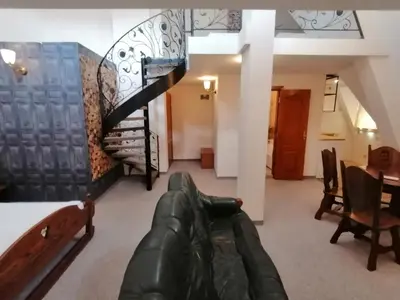 a living room with a couch and a spiral staircase at Hotel Aristokrat in Obzor