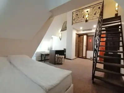 a bedroom with a staircase and a bed in a room at Hotel Aristokrat in Obzor