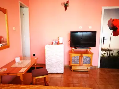a living room with a television and a table at Sadala Guest House in Nesebar