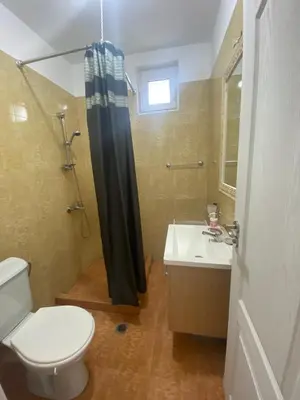 a bathroom with a toilet and a sink and a shower at Belvedere Apartments in Byala