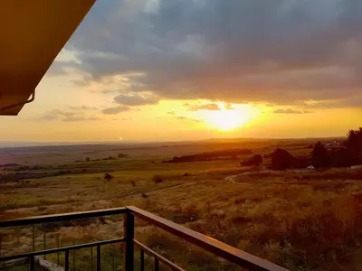 a sunset over a field with the sun in the sky at Belvedere Apartments in Byala