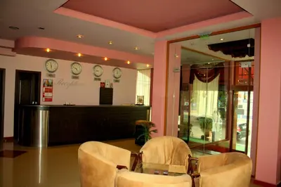 a waiting room with two chairs and clocks on the wall at Hotel Elegant in Karnobat