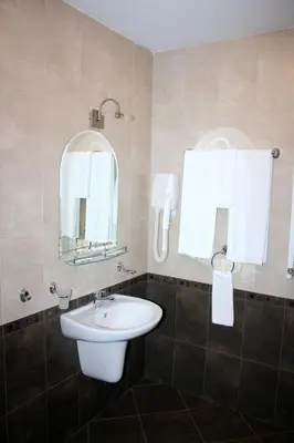 a bathroom with a sink and a mirror at Hotel Elegant in Karnobat