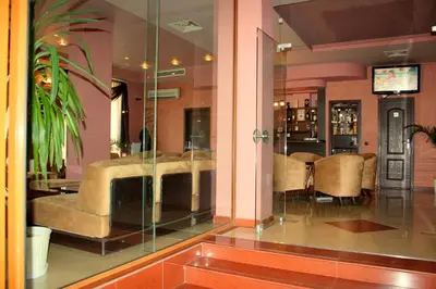 a lobby with a couch and a table and chairs at Hotel Elegant in Karnobat