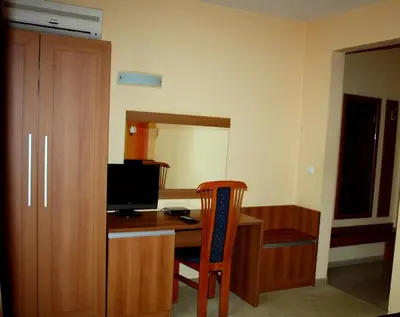 a room with a desk with a television and a chair at Hotel Elegant in Karnobat
