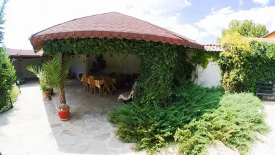 a gazebo with a table and chairs in a yard at Atanasovi House in Shkorpilovtsi
