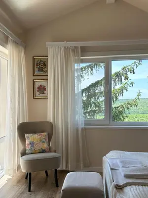 a bedroom with a chair and a window at Vila Sofia - Pool, Sauna & Nature Escape in Varna City