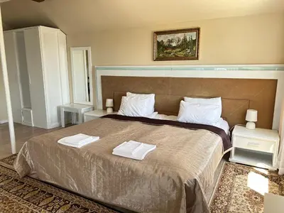 a bedroom with a large bed with two towels on it at Vila Sofia - Pool, Sauna & Nature Escape in Varna City