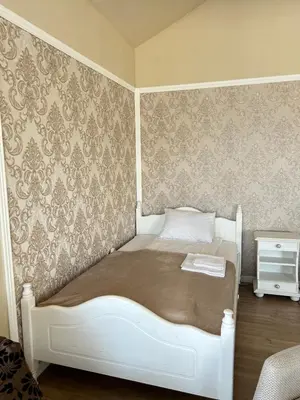 a white bed in a room with a wall at Vila Sofia - Pool, Sauna & Nature Escape in Varna City