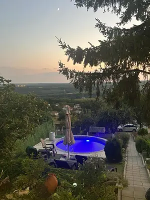 a pool in a yard with a umbrella and chairs at Vila Sofia - Pool, Sauna & Nature Escape in Varna City