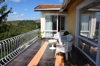 a balcony with two chairs and a table on it at Vila Sofia - Pool, Sauna & Nature Escape in Varna City