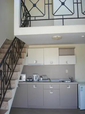 a kitchen with white cabinets and a staircase at Summer Breeze Apartments in Sunny Beach