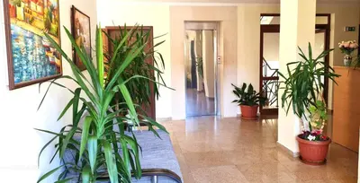 a hallway with potted plants in a building at Summer Breeze Apartments in Sunny Beach