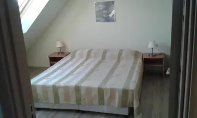 a bedroom with a bed with two nightstands and two lamps at Summer Breeze Apartments in Sunny Beach