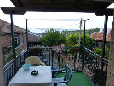 a patio with a table and chairs on a balcony at Guest House Zhelevi in Sozopol
