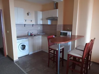 a kitchen with a table and chairs and a washing machine at St. George Guest House in Sveti Vlas