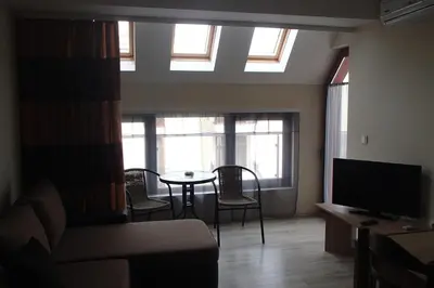 a living room with a couch and a table and windows at Sea'n'Pool Apartments in Hotel in Sozopol