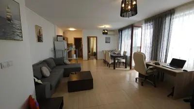a living room with a couch and a table with a laptop at Complex Top Apartment in Sveti Vlas