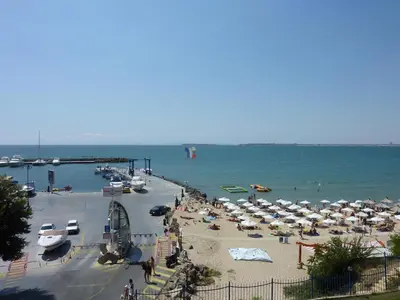 a beach with a bunch of umbrellas and the ocean at Complex Top Apartment in Sveti Vlas