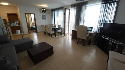 a living room with a couch and a television and a table at Complex Top Apartment in Sveti Vlas