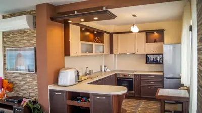 a kitchen with brown cabinets and a counter top at Guest House Meridi in Priseltsi