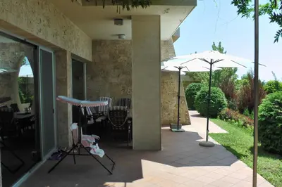 a patio with an umbrella and a table and chairs at Budzhaka Villa in Sozopol