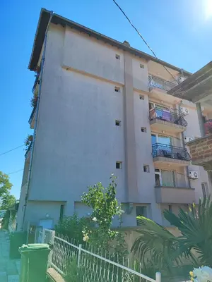 a tall building with a fence in front of it at Kovachevi House in Primorsko
