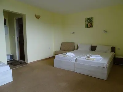 a bedroom with a bed and a couch in it at Kovachevi House in Primorsko