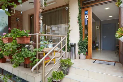 a store front with potted plants on the stairs at Nirvana Guest House in Nesebar