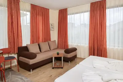 a living room with a couch and a bed at Nirvana Guest House in Nesebar