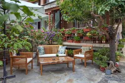 a patio with chairs and a table and flowers at Nirvana Guest House in Nesebar