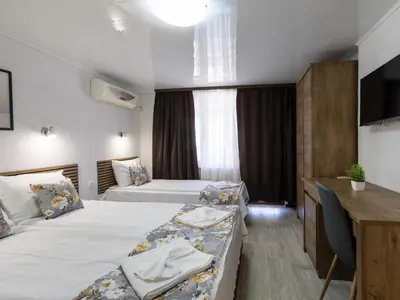 a hotel room with two beds and a desk at Home Gramatikovi in Pomorie