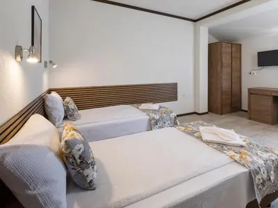 a bedroom with two beds and a tv at Home Gramatikovi in Pomorie