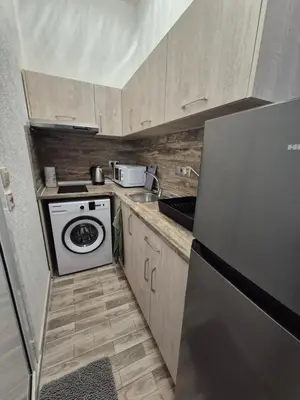 a small kitchen with a stove and a refrigerator at Студио Лазур Поморие in Pomorie