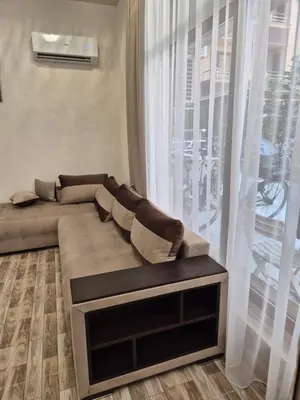 a couch in a living room with a large window at Студио Лазур Поморие in Pomorie