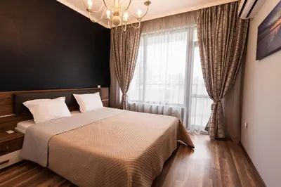 a bedroom with a bed and a large window at Green Paradise Deluxe Apartments in Primorsko