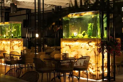 a restaurant with a large aquarium and tables and chairs at Rome Palace Deluxe - All Inclusive Premium in Sunny Beach