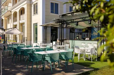 a group of tables and chairs in front of a building at Rome Palace Deluxe - All Inclusive Premium in Sunny Beach