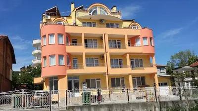 a tall yellow and orange building at Zlatevi Guest House in Obzor