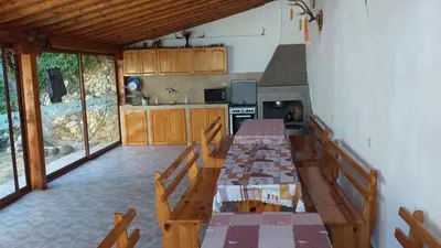 a dining room with a table and a kitchen at Zlatevi Guest House in Obzor
