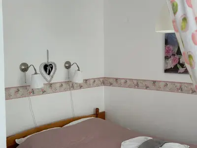 a bedroom with a bed and two lights on the wall at Apartments Panorama Ravda in Ravda
