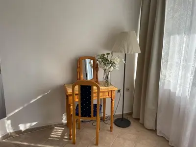 a table with a vase of flowers and a lamp at Apartments Panorama Ravda in Ravda