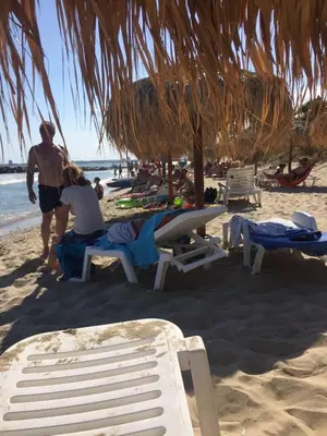 a group of people sitting on the beach at Siana 1 Apartment in Sveti Vlas