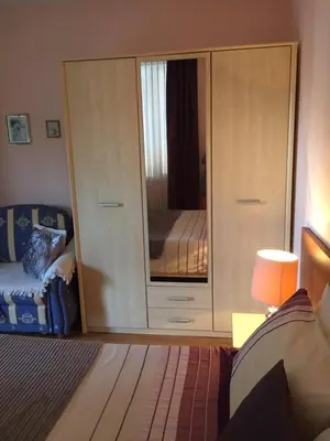 a bedroom with a large cabinet with a mirror at Siana 1 Apartment in Sveti Vlas