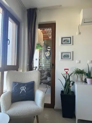 a living room with a chair and a door at Paradise Bay D8 Apartment in Sozopol