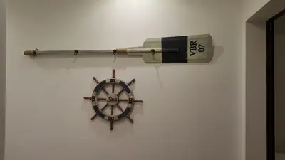 a wall with a wheel and a book on it at Guest Rooms Old Captain in Burgas City