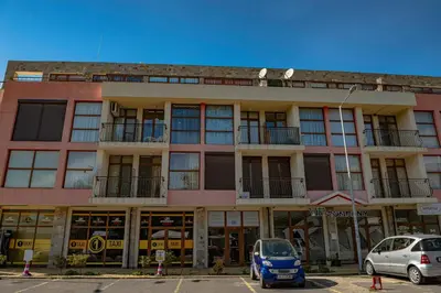 a building with cars parked in front of it at Menada Crystal Park Apartments in Sunny Beach
