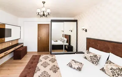 a bedroom with a large bed and a television at Stela Apartments in Obzor