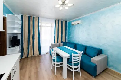 a living room with a blue couch and a table and chairs at Stela Apartments in Obzor