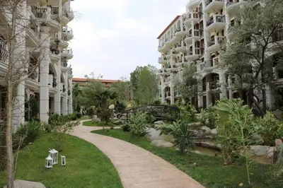 a walkway through a park next to a building at Private Apartments in Harmony Suites Dream Island in Sunny Beach